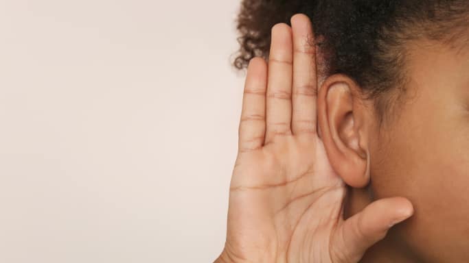 Personne qui tend l'oreille pour entendre